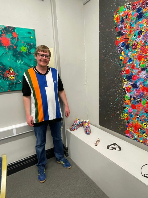 John Hindle in front of artwork
